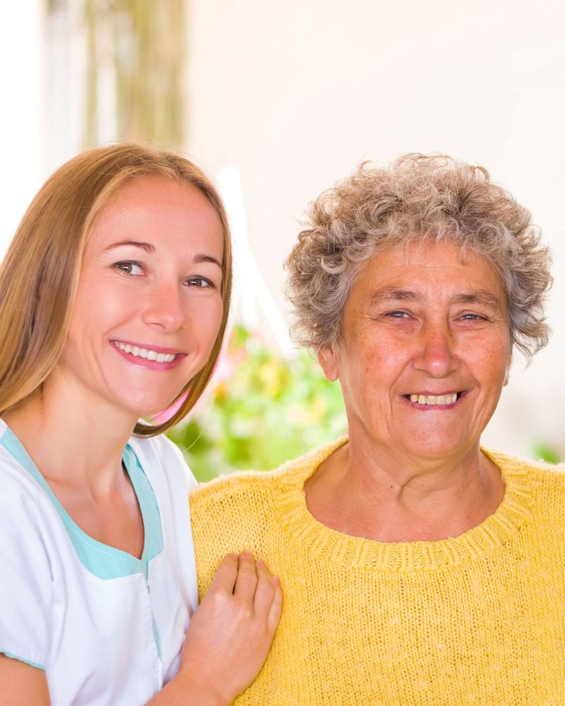 Care staff supporting an elderly person in a residential care home